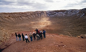 Visitors take a guided tour of a meteor impact site at Meteor Crater